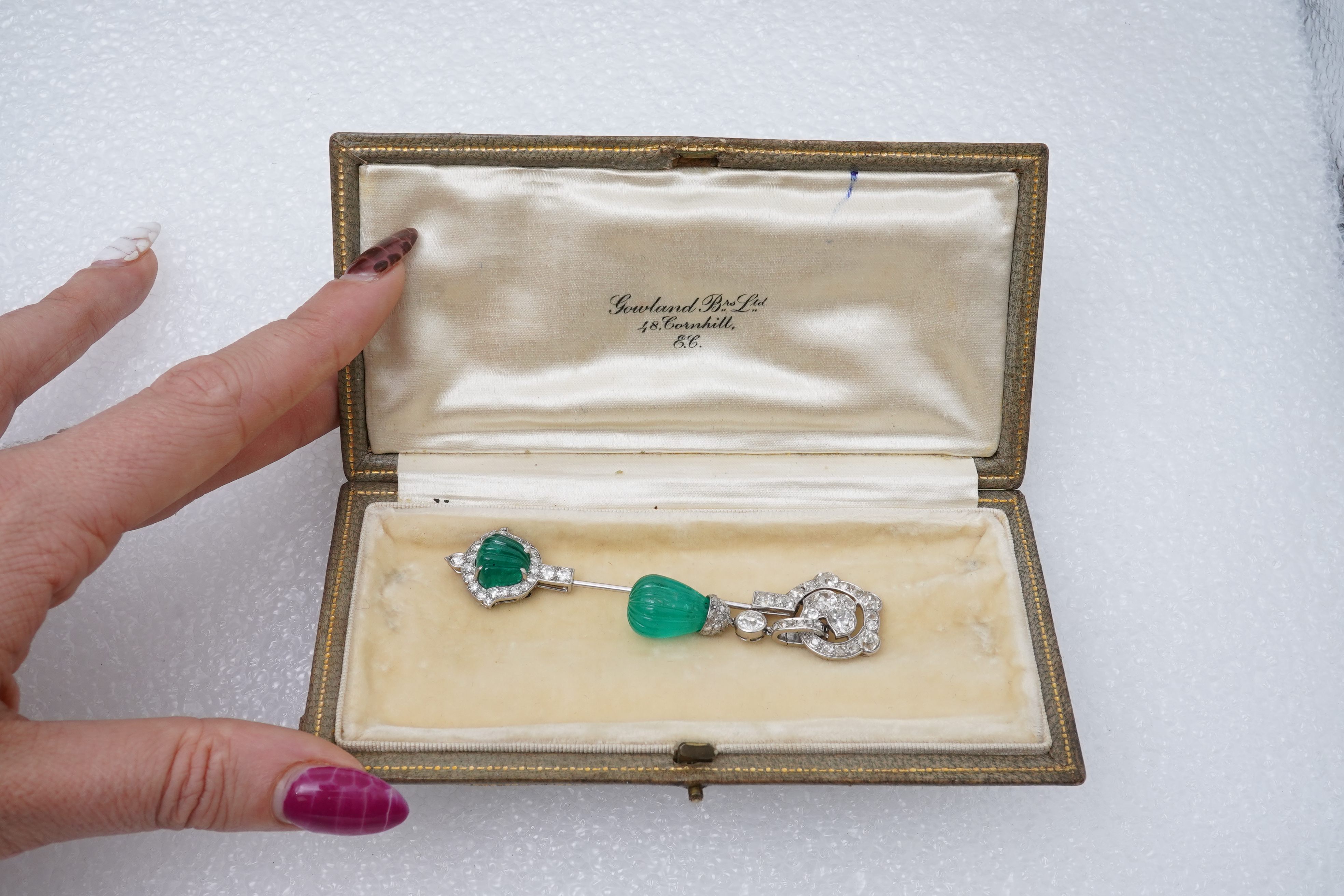 A fine Art Deco carved emerald and diamond jabot pin, circa 1925